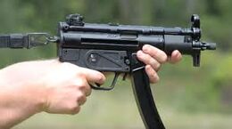 An MP5K being held.