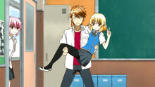 Kenji carrying Roka in his arms.