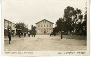 בית הכנסת הגדול בראשון לציון, נוסד ב-1885. מבט מכיכר המיסדים. מצד ימין לבית הכנסת הפוסטה (דואר) ובית המרקחת, גלויה בהוצאת האחים אליהו, יפו. התמונה צולמה במוזיאון וארכיון העיר ראשון לציון