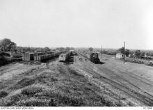 תחנת ה רכבת בלוד - Ludd, Palestine. c. 1917. The railway station showing a goods train passing through with several goods vans parked on sidings. (Donor Imperial War Museum Q15195)