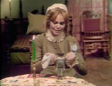 Angelique casting a spell using a doll.