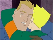 A white man with a tear running down his cheek hugging a white teenage boy.