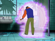 A black teenage boy looking in a mirror and concentrating while his previous form - a large glowing being - fades away.