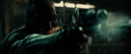 Batman fires a shot at a thug with his Grapple Gun