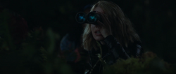 Harcourt watches Economos from a distance with her binoculars