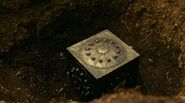 A Mother Box being buried by the humans