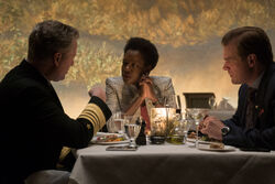 Amanda Waller sits at dinner with government officials