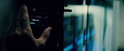 Bruce plugs a hacking device into the LexCorp mainframe