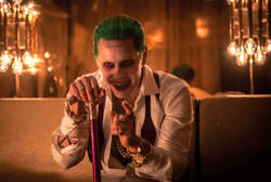 The Joker holds his cane and points