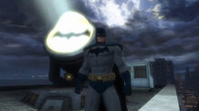 Batman standing beside his signal