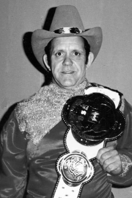 Former pro wrestler Nelson Royal poses with his title belt in this 1999  file photo at his western wear store in Mooresville, N.C. Royal died  Sunday, Feb. 3, 2002 while visiting a