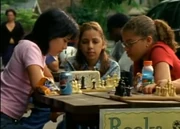 Nadia watching a game of chess between Kendra and Liberty.