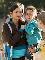 Mia holding Isabella while talking to Holly J in "Uptown Girl"