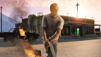 Trevor neben einem brennenden Wrack