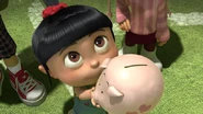 Agnes giving the piggy bank to Gru.