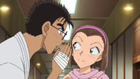 Makoto whispering to blushing Sonoko.