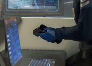 Border guard goes to pick up his temperature scanner.