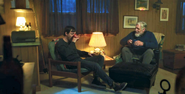 Harrison drinking whiskey with Kurt in the cabin