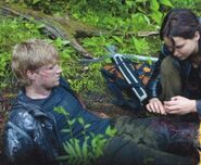 Katniss versucht Peeta so gut sie kann zu verarzten. Weil sie ein unglückliches Paar spielen sollen ...