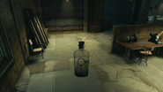 Corvo holds the bottle containing the locked cabinet key in the workshop.