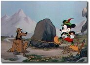 Mickey ties Pluto up to the rock