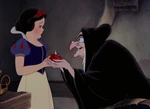 The Queen offering the poisoned apple to Snow White.