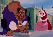 Bestia y Bella le dan de comer a un pájaro.