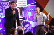 Bob Saget and Gilbert Gottfried speak onstage during the Scleroderma Research Foundation's 30th Anniversary Cool Comedy-Hot Cuisine in New York in December 2017.