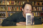 Billy Crystal poses with a copy of his self-biography book 700 Sundays in May 2005.