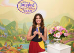 Mandy Moore holding a Rapunzel doll promoting Tangled: The Series.