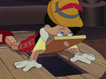 Pinocchio fell down and gets his nose stuck.