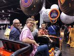 Swampy sitting down with Vincent and Dan in a mini car at 2019's D23.
