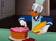 Donald putting icing on a cake