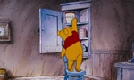Winnie the Pooh is reaching the honey pot in the cupord