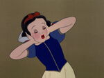 Snow White covers her ears as Sneezy is about to sneeze