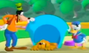 Goofy and Donald comforting Pluto, who is sadly laying in his doghouse.