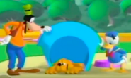 Goofy and Donald comforting Pluto, who is lying sadly in his doghouse.