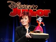 Mama Hook's voice actress Sharon Osbourne holding a Mama Hook action figure