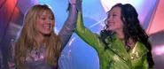 Isabella and Lizzie holding hands triumphantly after the latter's performance.