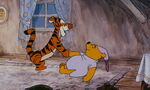 Tigger is shakeing Pooh Bear's paw