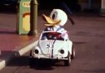 Donald riding in a tiny version of Herbie, the Love Bug