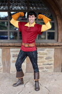 2019-Present: Gaston now closely resembles his animated counterpart. His shirt now has short sleeves and more detailed, with grommets and laces to his neck collar, and a yellow long sleeved undershirt. He still has his light brown gloves and belt, but is boots are now a darker brown, and his pants are black.