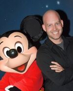 Bret Iwan posing for a photo with Mickey.