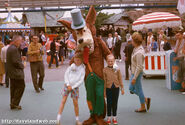 In the 1960s, the Big Bad Wolf costume was on two legs and began to resemble his animated version, but he has brown fur, green overalls and a gray hat with a green stripe.