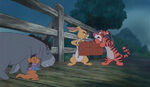 Rabbit and Tigger arguing over Piglet's scrapbook as a map to find him, which causes it to fall into the river.