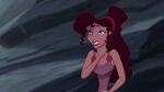 Grimacing, Meg clutches her throat after the Hydra swallows Hercules whole.