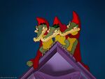 Three Alligators are wearing red capes with triangle shaped hoods on them.