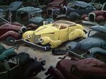 A beaten used up yellow motor car