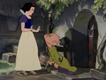 Dopey tries to get a kiss from Snow White.