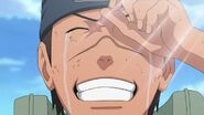 Iruka happily cries now that Naruto is a hero for saving Konoha.